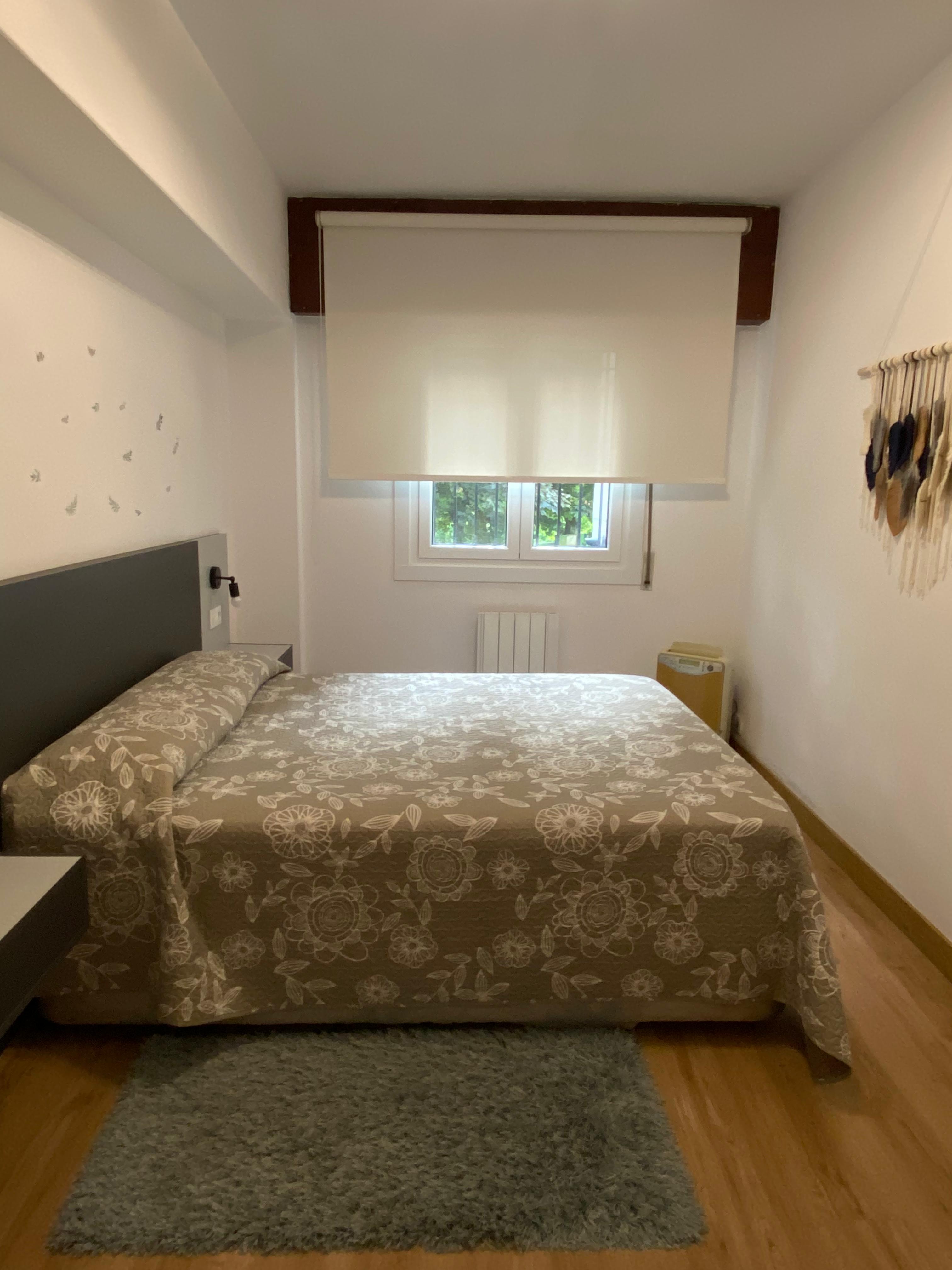 Habitación doble con colcha floral y macramé