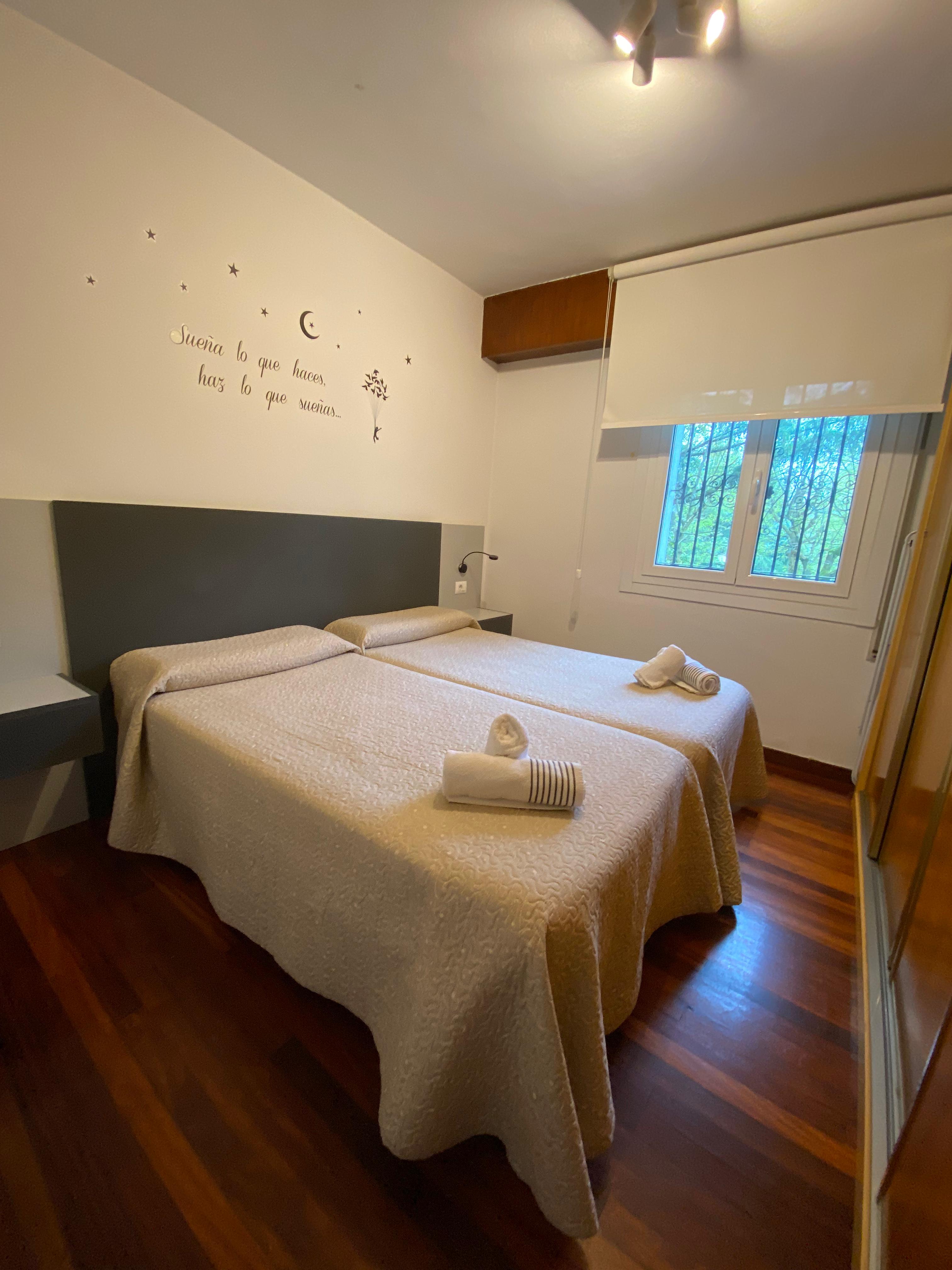 Habitación con dos camas y suelo de madera