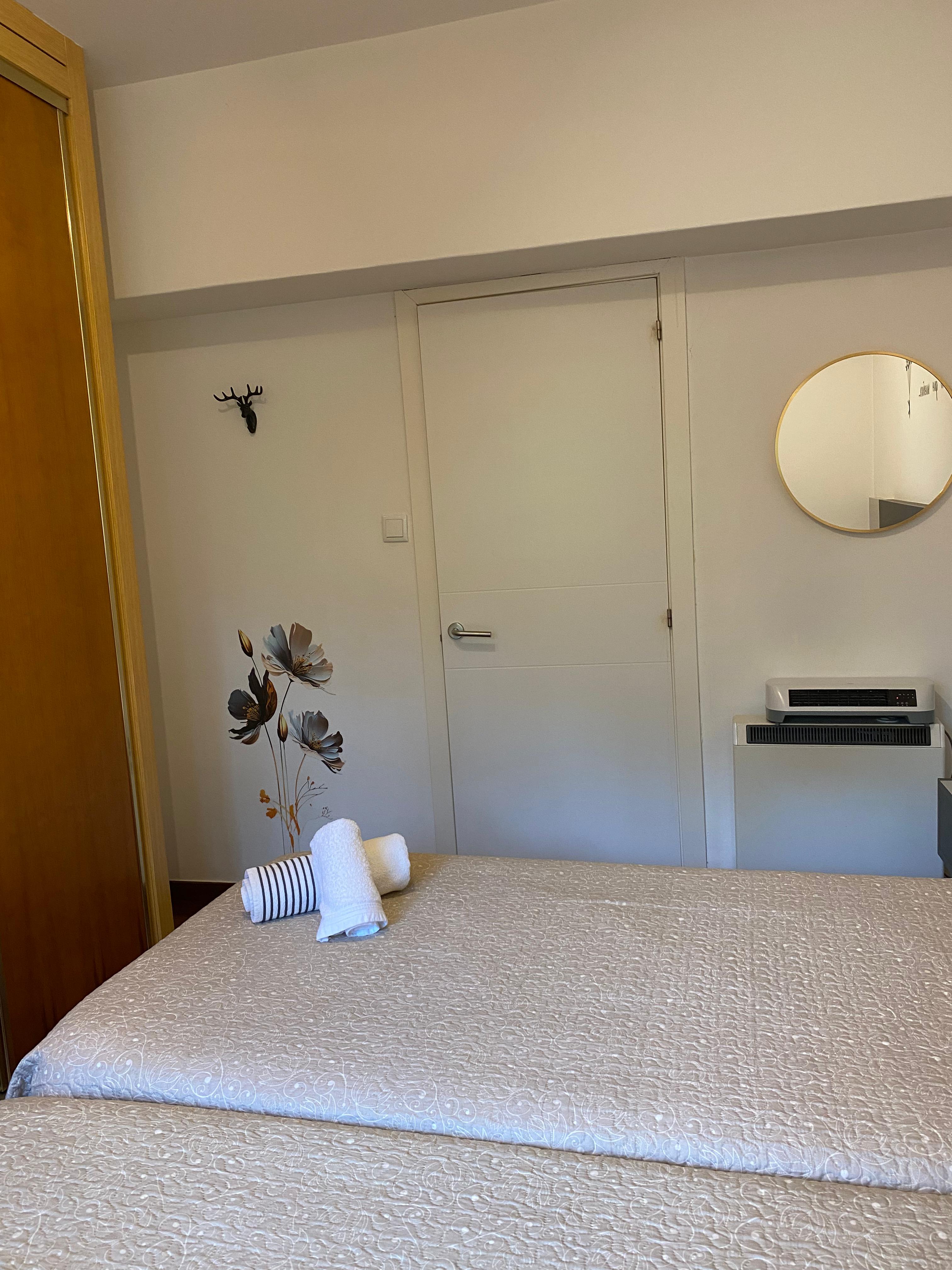 Habitación doble con espejo dorado y toallas